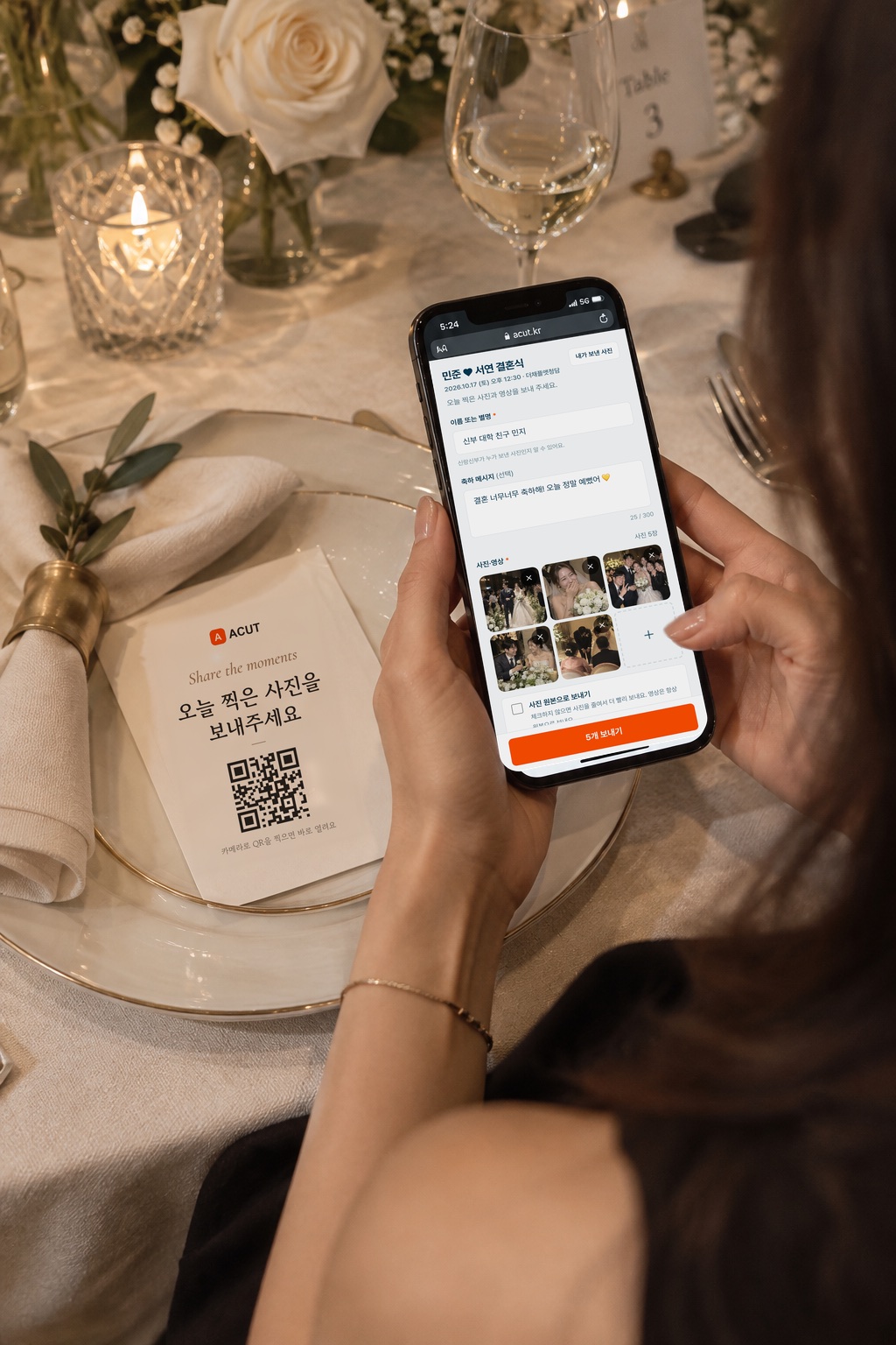 식장 테이블의 QR 안내판 옆에서 하객이 휴대폰으로 하객 앨범에 사진 5장을 보내는 장면